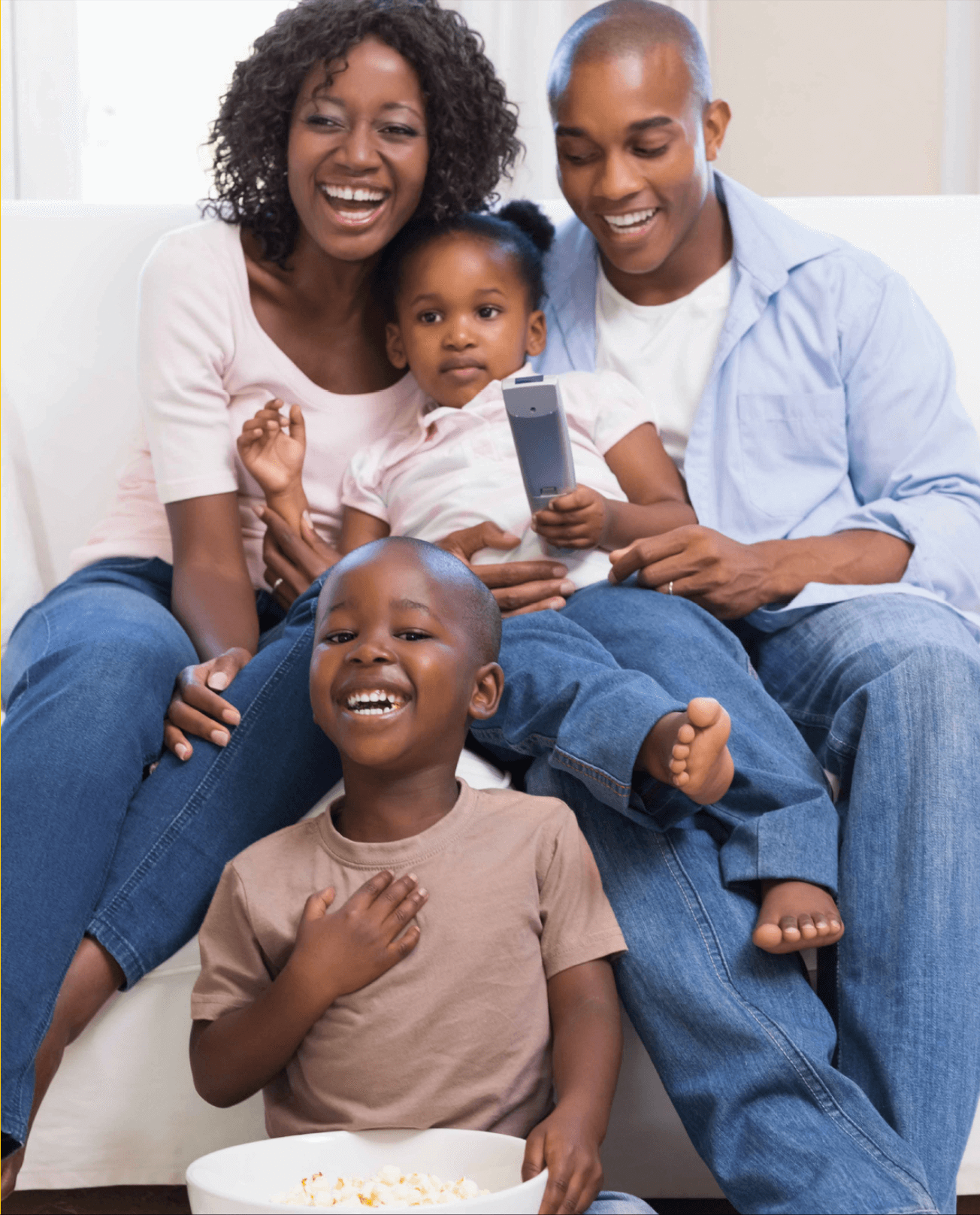 Happy family of four looking at tablet together - parents and two children smiling